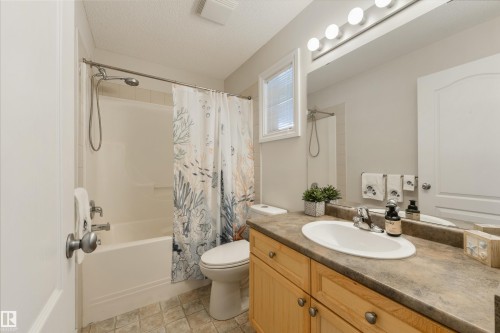Bathroom featuring a vanity with a sink, a bathtub with a shower, and a toilet - 67 12050 17 Avenue, Edmonton, AB - Indoor Photo Showing Bathroom