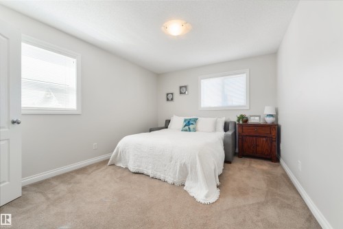 This room features two windows, light colored walls, and carpeting - 67 12050 17 Avenue, Edmonton, AB - Indoor Photo Showing Bedroom
