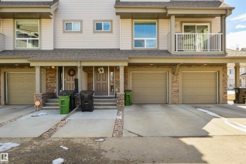 The property features a multi-level design with light-colored siding and a covered entrance - 67 12050 17 Avenue, Edmonton, AB - Outdoor With Balcony With Facade