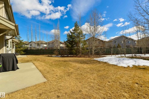 The property features an extensive yard with a paved patio area and mature trees - 67 12050 17 Avenue, Edmonton, AB - Outdoor