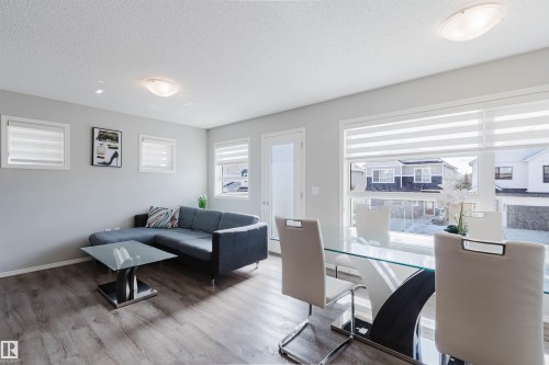 Living and dining area featuring light-colored walls, recessed lighting, and durable flooring throughout - 17268 9B Avenue, Edmonton, AB 