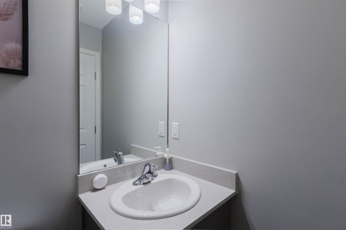 Bathroom featuring a corner vanity with a light-colored countertop, an undermount sink, and a chrome faucet - 17268 9B Avenue, Edmonton, AB 