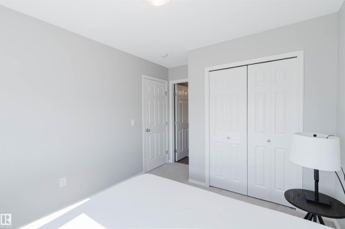 This room features light gray walls, a white ceiling with a flush-mount light, and white bi-fold closet doors - 17268 9B Avenue, Edmonton, AB 