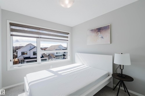 The property features a bright room with a large window, offering views of the surrounding neighborhood - 17268 9B Avenue, Edmonton, AB 