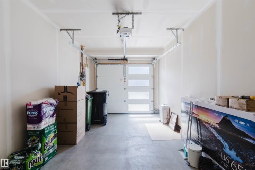 The property includes a garage with a white garage door featuring frosted glass panels and a concrete floor - 17268 9B Avenue, Edmonton, AB 
