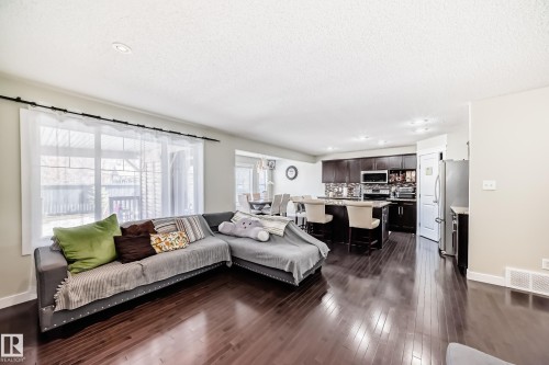 The property features rich hardwood flooring throughout the main living areas - 3433 Goodridge Link Link, Edmonton, AB - Indoor Photo Showing Living Room