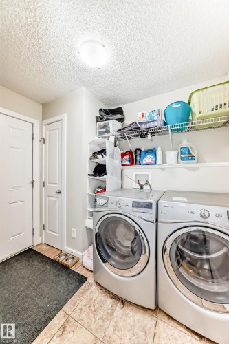Laundry area featuring tile flooring, white doors, and overhead lighting - 3433 Goodridge Link Link, Edmonton, AB - Indoor Photo Showing Laundry Room