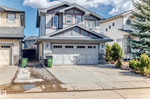 The property features a two-story exterior with light-colored siding and stone accents - 3433 Goodridge Link Link, Edmonton, AB - Outdoor With Facade