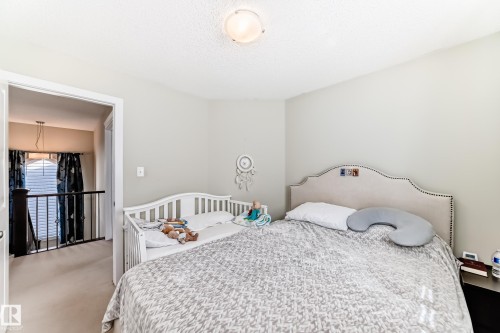 This room offers light-colored walls and carpet flooring, featuring a light fixture on the ceiling - 3433 Goodridge Link Link, Edmonton, AB - Indoor Photo Showing Bedroom
