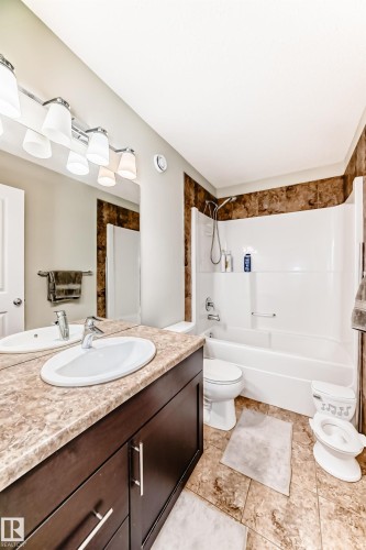 Bathroom featuring a vanity with a light brown countertop, a white sink, and a large mirror - 3433 Goodridge Link Link, Edmonton, AB - Indoor Photo Showing Bathroom