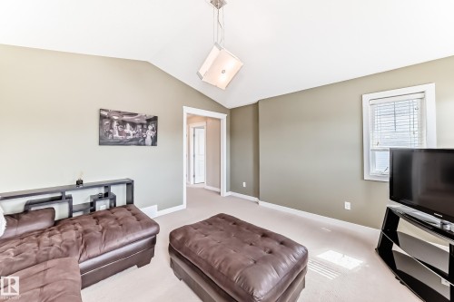 This room features vaulted ceilings, light-colored carpeting, and a window with blinds providing natural light - 3433 Goodridge Link Link, Edmonton, AB - Indoor