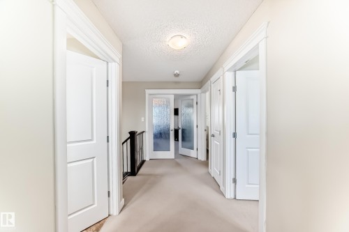 The property features a bright hallway with light-colored walls and carpeted flooring - 3433 Goodridge Link Link, Edmonton, AB - Indoor Photo Showing Other Room