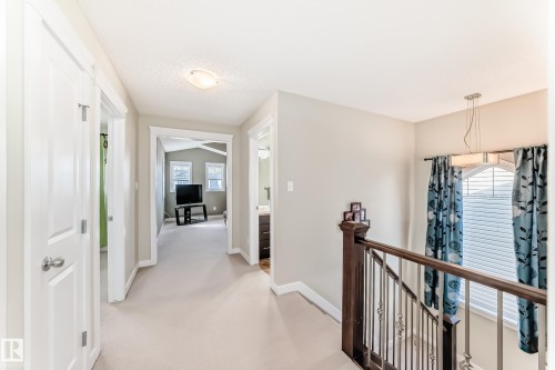 This hallway features neutral-toned carpeting and walls, white trim, and doors - 3433 Goodridge Link Link, Edmonton, AB - Indoor Photo Showing Other Room