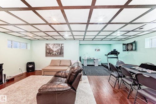 The property features a spacious room with hardwood floors and a coffered ceiling - 3433 Goodridge Link Link, Edmonton, AB - Indoor