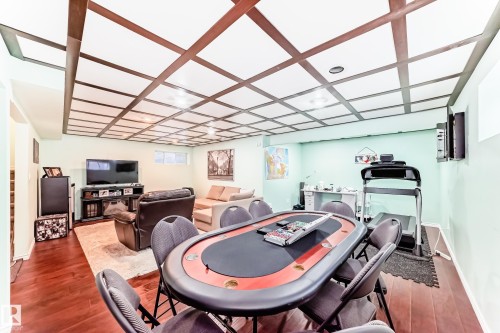 Versatile recreational area featuring rich wood flooring and a coffered ceiling - 3433 Goodridge Link Link, Edmonton, AB - Indoor