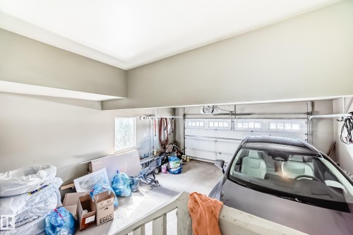 Garage featuring a white overhead door with window inserts and a concrete floor - 3433 Goodridge Link Link, Edmonton, AB - Indoor Photo Showing Garage