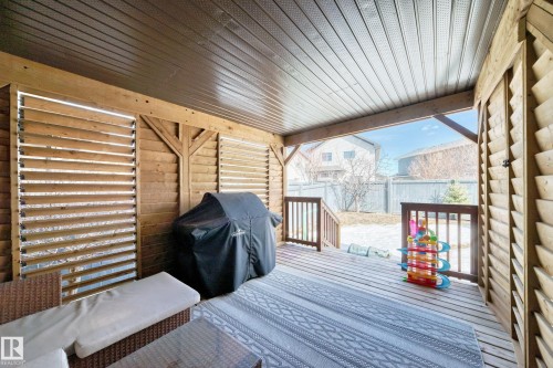This property features a covered wood deck with a slatted ceiling, wood paneling, and louvered privacy screens - 3433 Goodridge Link Link, Edmonton, AB - Outdoor With Deck Patio Veranda With Exterior