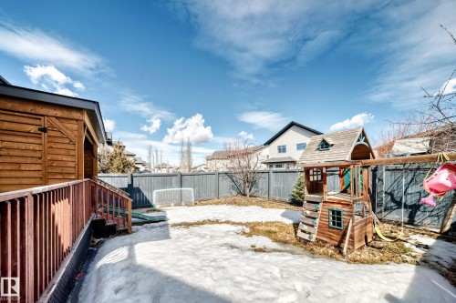 The property features a fenced backyard with a wooden shed and a play structure - 3433 Goodridge Link Link, Edmonton, AB - Outdoor