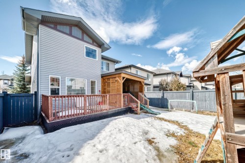 Rear exterior view of the property, featuring a wooden deck with railing, a wooden covered patio area, and a fenced yard - 3433 Goodridge Link Link, Edmonton, AB - Outdoor With Deck Patio Veranda With Exterior
