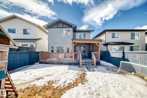 The property features a private backyard with a wooden fence and a spacious wooden deck, partially covered by a pergola - 3433 Goodridge Link Link, Edmonton, AB - Outdoor With Deck Patio Veranda