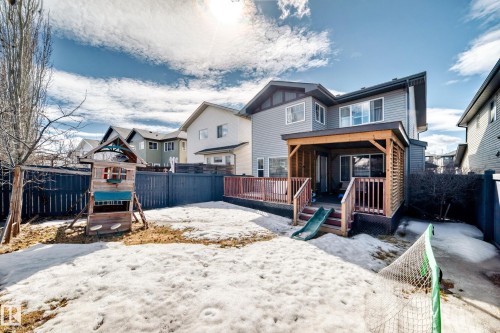 The property features a fenced backyard with a covered patio and a wooden deck - 3433 Goodridge Link Link, Edmonton, AB - Outdoor With Deck Patio Veranda