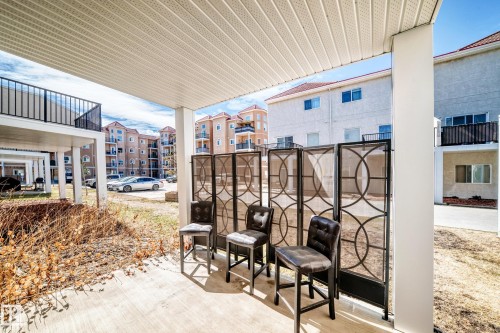 The property features an outdoor patio area with a privacy screen and space for seating - 44 13825 155 Avenue, Edmonton, AB - Outdoor With Exterior