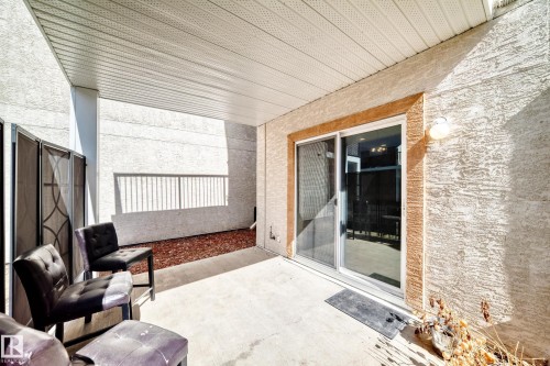 The property features a covered patio with a concrete floor, stucco exterior, and a sliding glass door - 44 13825 155 Avenue, Edmonton, AB - Outdoor With Exterior