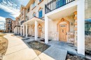 This property features a stucco exterior with stone accents, arched entryways, and covered porches - 44 13825 155 Avenue, Edmonton, AB  - Outdoor With Facade 