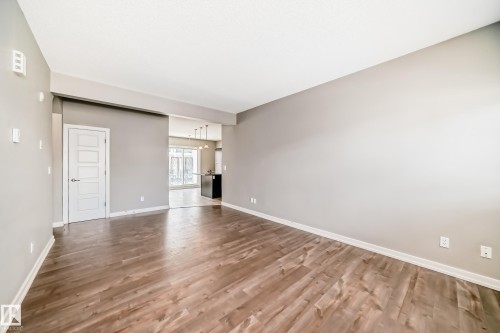 This expansive room features light-toned walls and wood flooring - 44 13825 155 Avenue, Edmonton, AB - Indoor Photo Showing Other Room