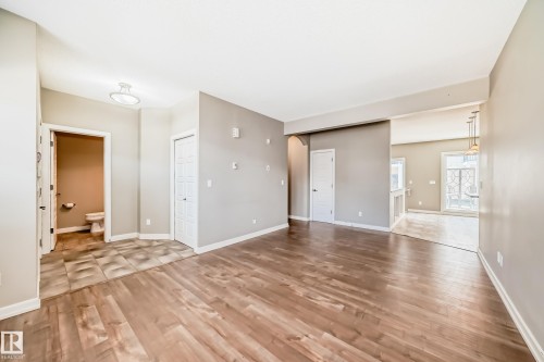 The property features hardwood flooring and light gray walls, with a tiled area near the entrance - 44 13825 155 Avenue, Edmonton, AB - Indoor Photo Showing Other Room