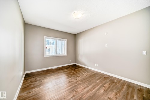 This room features light-colored walls and dark wood-look flooring - 44 13825 155 Avenue, Edmonton, AB - Indoor Photo Showing Other Room