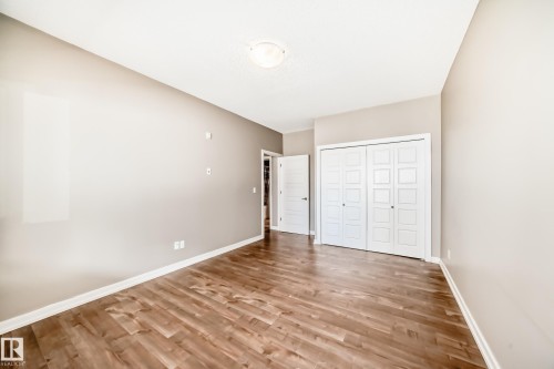 The room features hardwood style flooring, light neutral-toned walls, and a white ceiling - 44 13825 155 Avenue, Edmonton, AB - Indoor Photo Showing Other Room