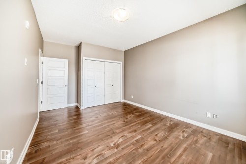 This room features rich wood flooring, neutral tone walls, a ceiling light fixture, and white trim - 44 13825 155 Avenue, Edmonton, AB - Indoor Photo Showing Other Room