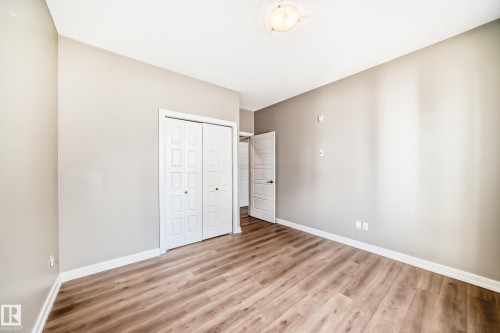 The room features wood-look flooring, light-colored walls, and a white ceiling - 44 13825 155 Avenue, Edmonton, AB - Indoor Photo Showing Other Room