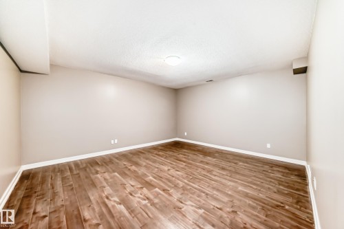 Spacious room featuring wood flooring, light-colored walls, and a ceiling light fixture - 44 13825 155 Avenue, Edmonton, AB - Indoor Photo Showing Other Room