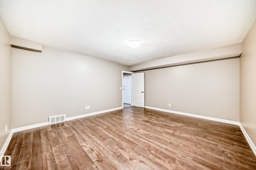 Spacious room featuring wood flooring, light-colored walls, and a ceiling-mounted light fixture - 44 13825 155 Avenue, Edmonton, AB - Indoor Photo Showing Other Room