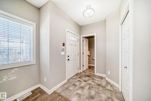 Entryway featuring a window with blinds, a white door with transom lites, and tiled flooring - 44 13825 155 Avenue, Edmonton, AB - Indoor Photo Showing Other Room