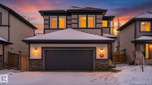 The property features a two-story design with a prominent garage and stone accents on the facade - 13 Spring Link, Spruce Grove, AB - Outdoor