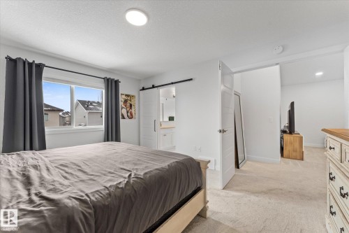 The bedroom features a window providing natural light, white walls, and light-colored carpeting - 13 Spring Link, Spruce Grove, AB - Indoor Photo Showing Bedroom
