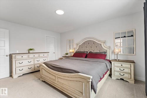 This bedroom features light-colored carpeting, white walls, and a recessed ceiling light - 13 Spring Link, Spruce Grove, AB - Indoor Photo Showing Bedroom