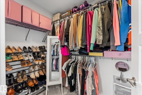 The property offers a walk-in closet with extensive hanging storage and shelving for organization - 13 Spring Link, Spruce Grove, AB - Indoor With Storage