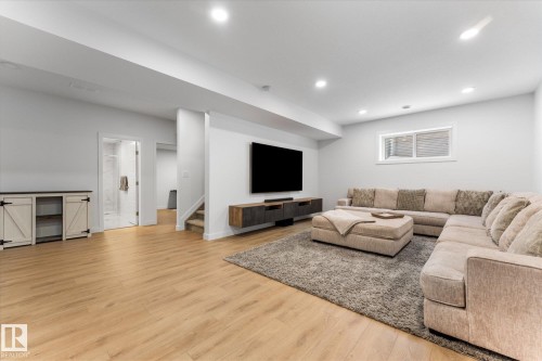 Spacious living area featuring light-colored flooring, recessed lighting, and a window providing natural light - 13 Spring Link, Spruce Grove, AB - Indoor Photo Showing Living Room