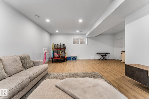 This spacious room features light-toned flooring, recessed lighting, and a window providing natural light - 13 Spring Link, Spruce Grove, AB - Indoor Photo Showing Other Room