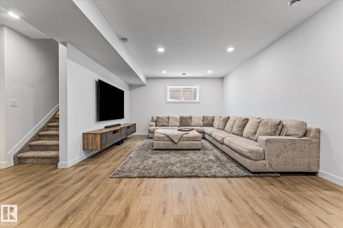 Spacious living area featuring light wood flooring, recessed lighting, and a window providing natural light - 13 Spring Link, Spruce Grove, AB - Indoor