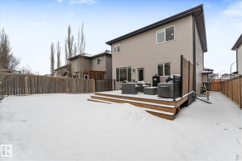The property features a spacious backyard with a wooden fence and a multi-level deck - 13 Spring Link, Spruce Grove, AB - Outdoor With Deck Patio Veranda With Exterior