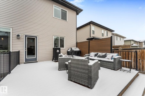 The property features a spacious elevated deck with a privacy screen and a wooden fence - 13 Spring Link, Spruce Grove, AB - Outdoor With Deck Patio Veranda With Exterior