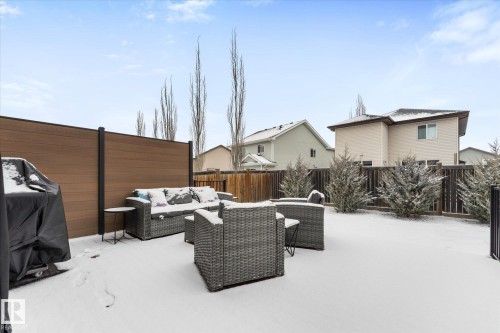 The property features a fenced backyard with a patio area and shrubbery - 13 Spring Link, Spruce Grove, AB - Outdoor With Deck Patio Veranda With Exterior