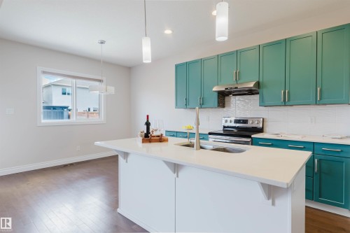 Kitchen featuring a central island with a sink, white countertops, and teal-colored cabinetry - 4875 Wright Drive, Edmonton, AB - Indoor Photo Showing Kitchen With Double Sink With Upgraded Kitchen