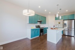 The kitchen features vibrant blue cabinetry, stainless steel appliances, a white island with a sink, and hardwood flooring - 