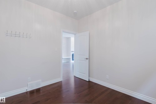 The room features dark wood flooring, white walls, and white trim - 4875 Wright Drive, Edmonton, AB - Indoor Photo Showing Other Room